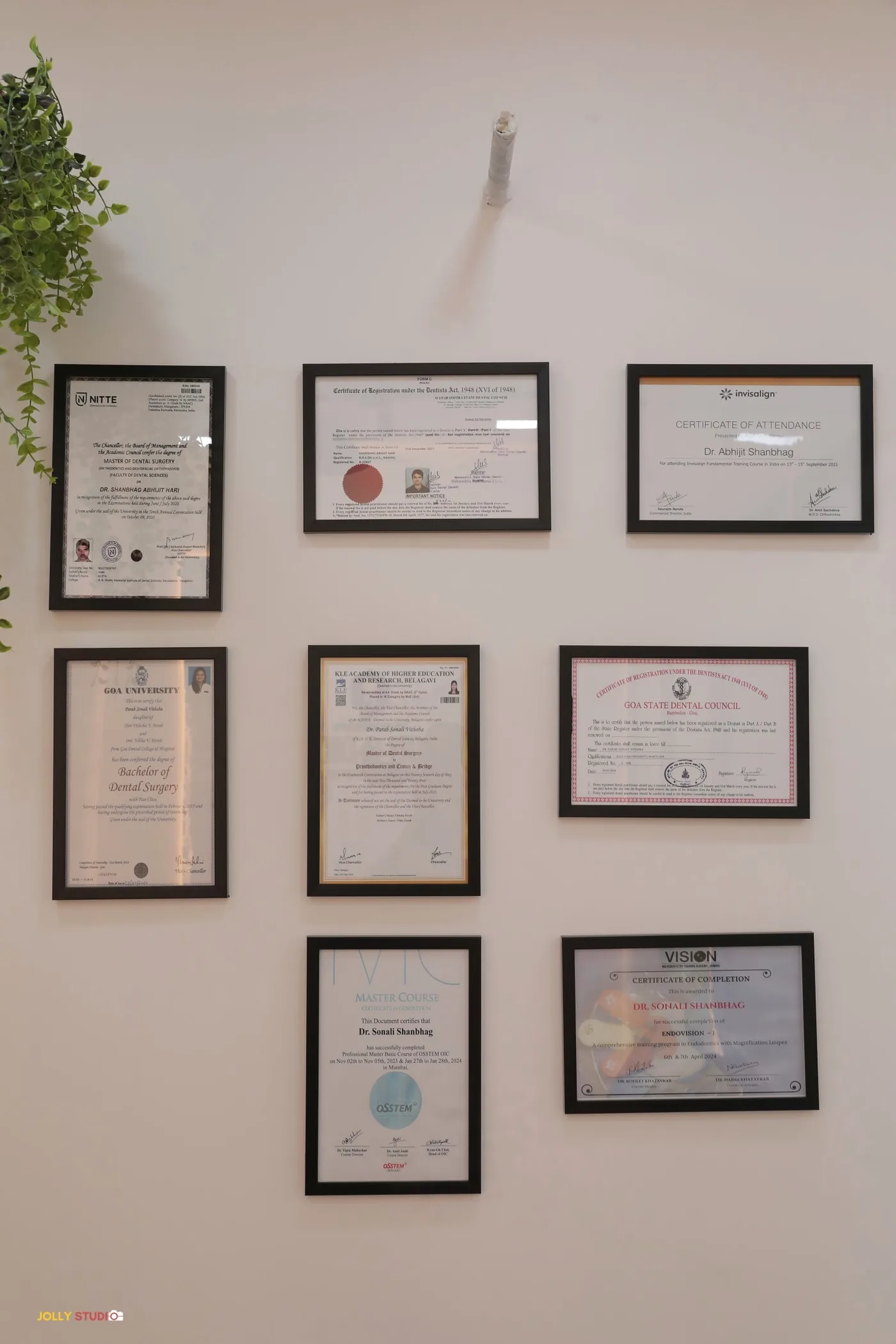 Wall of degrees and certifications at Align-O-Dent — NITTE, KLE VKIDS, Invisalign, Goa University